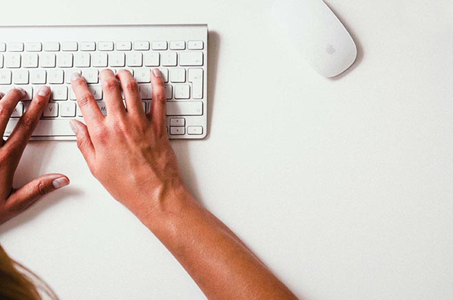 Hands typing on computer